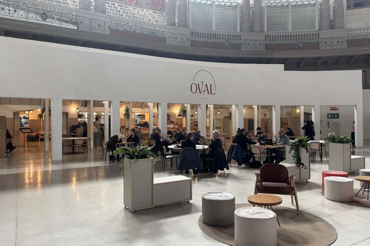 Oval Café en la sala oval del MNAC Barcelona con visitantes y el logo del café visible